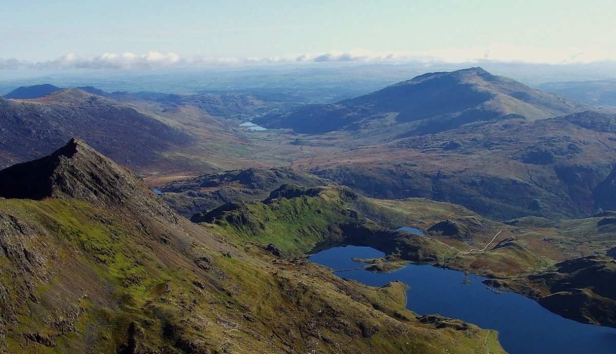 Panoramic view of Snowdonia mountains with deep blue lakes nestled in green valleys
