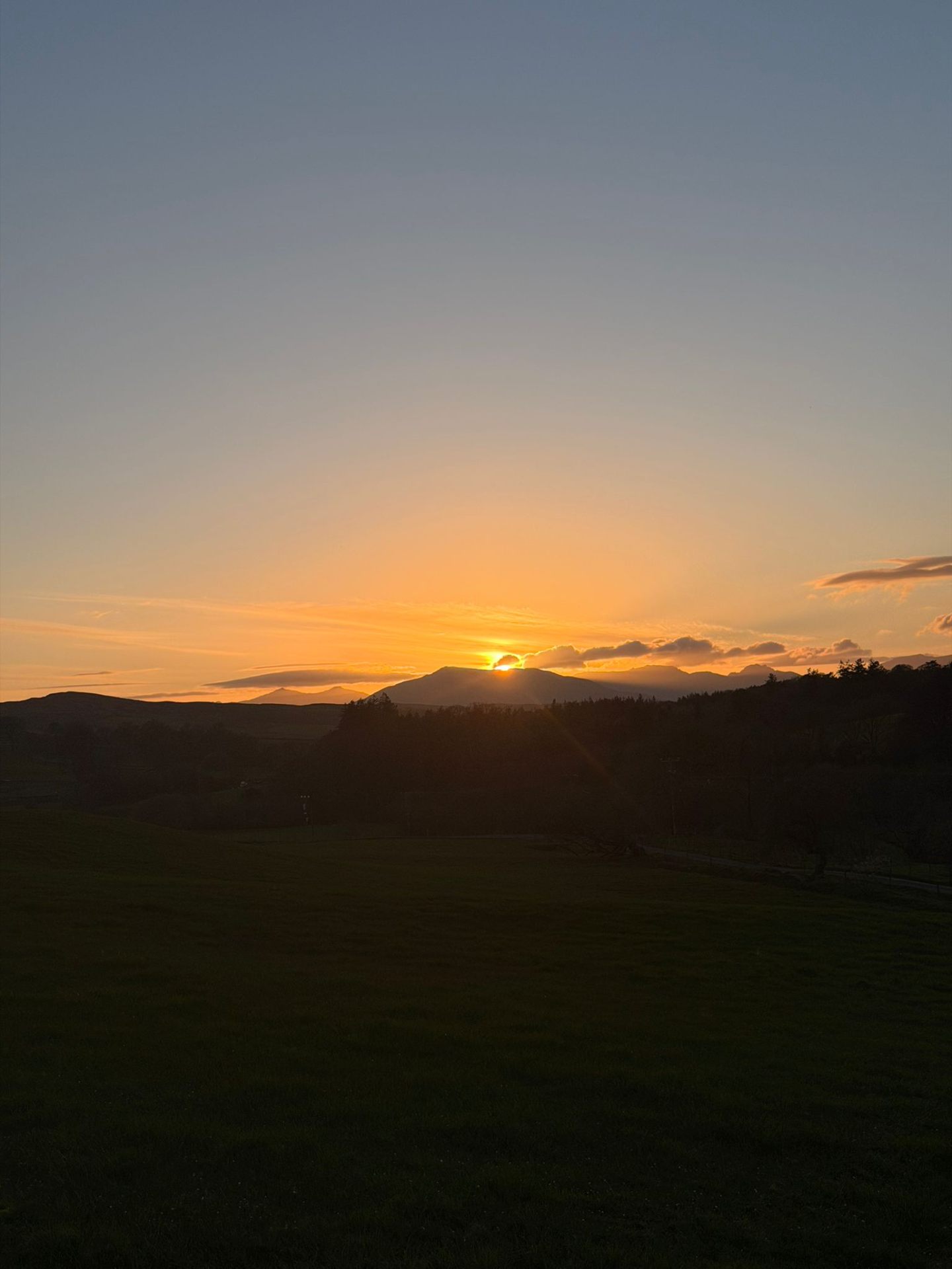 Sunset over the peaks of Eryri with an amber sky